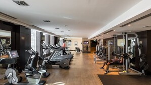 A gym with treadmills, elliptical machines, and weightlifting equipment. - Exclusive Duplex Villa w Panoramic Terrace Overlooking Burj Khalifa (Dubai)