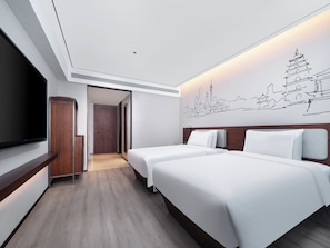 Habitación de hotel con dos camas, un televisor, un armario de madera y un cuadro de arte urbano.