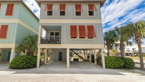 A two-story building with a balcony and a covered entrance area. - Drift Away (Gulf Shores)
