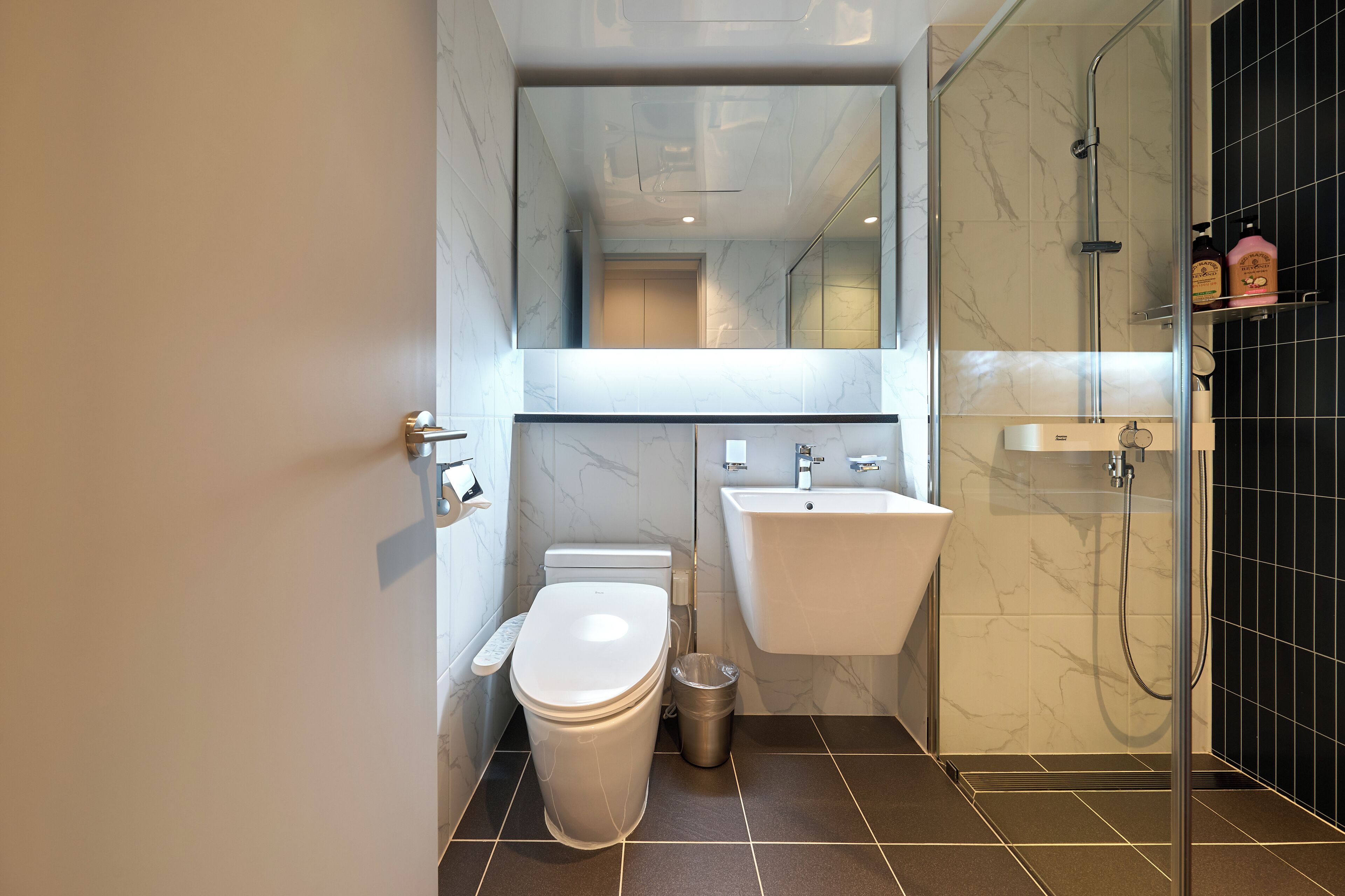 A modern bathroom with a toilet, sink, and shower.