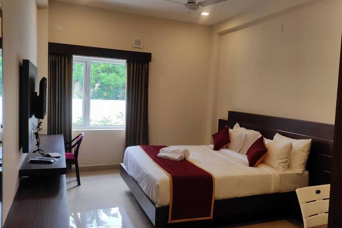 Une chambre d’hôtel avec un lit, un bureau et une chaise.