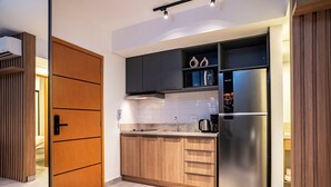A modern kitchen with wooden cabinets, a stainless steel refrigerator, and a microwave.