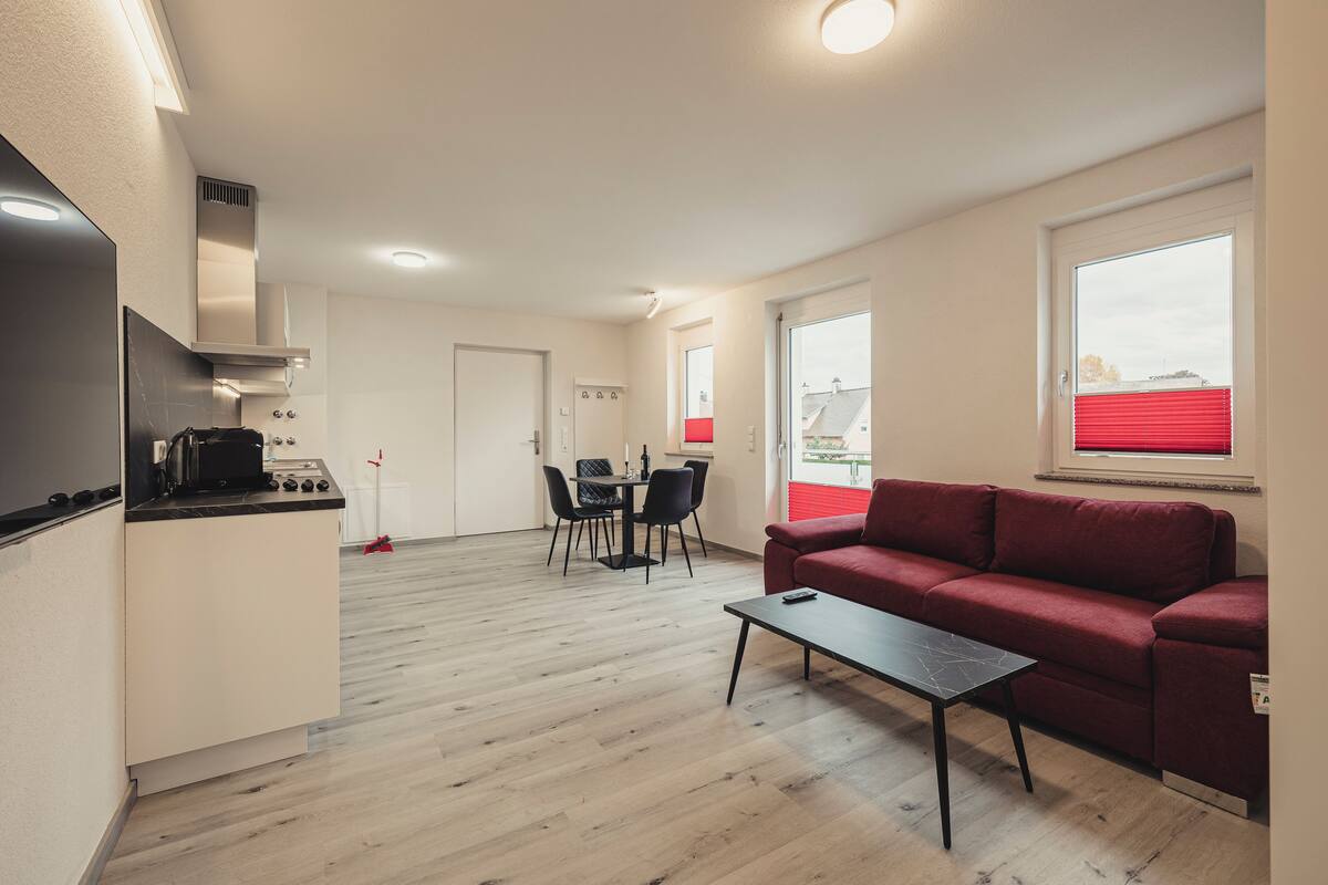 A modern apartment with a kitchen, dining area, and living room.