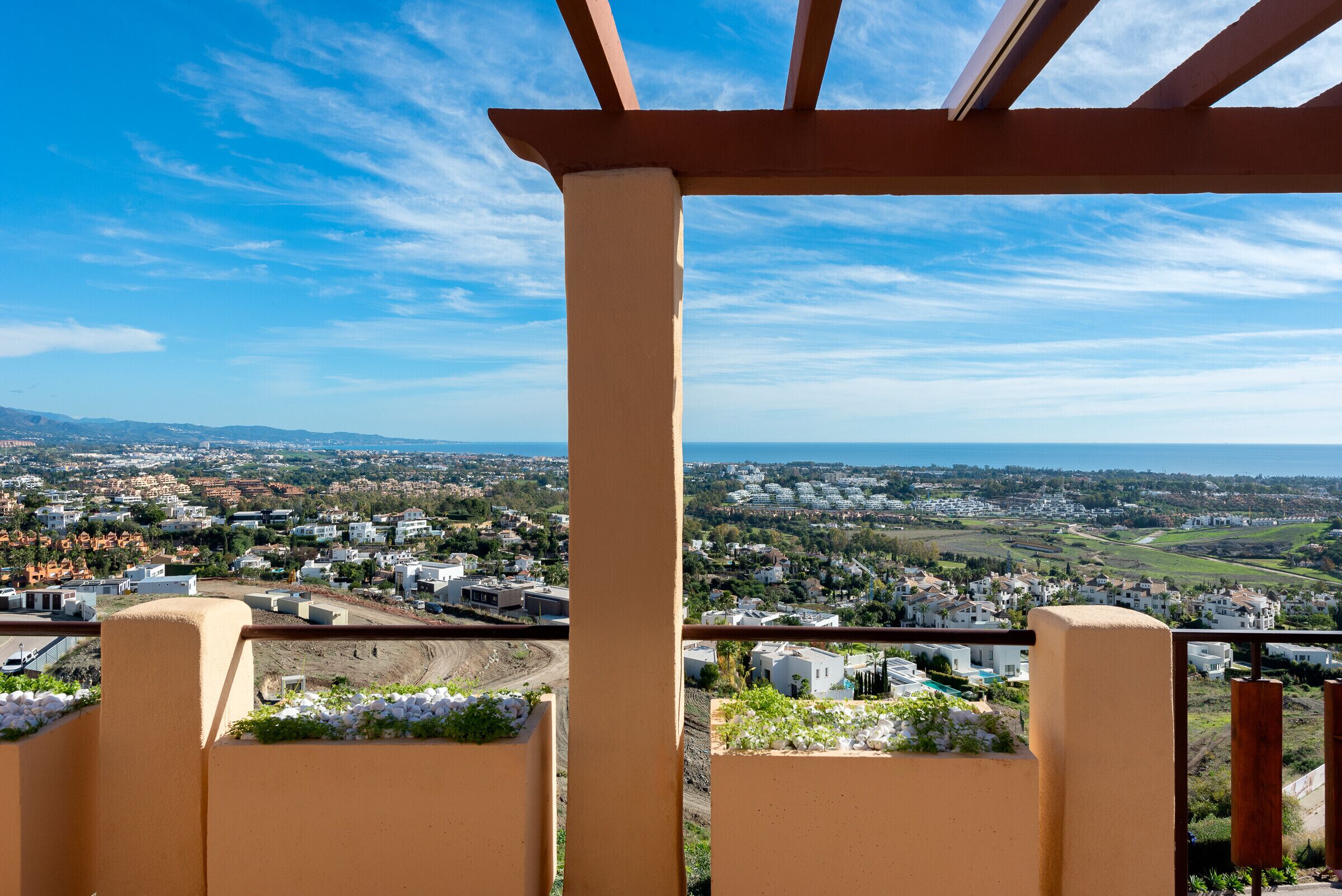 A balcony with a view of a residential area and a clear sky.