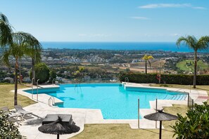 A swimming pool with a view of the ocean and a cityscape in the background. - Premium Penthouse with Unmatched Views (Benahavís)