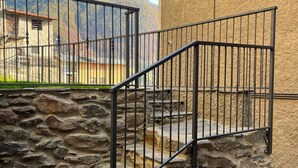 Eine Steintreppe mit Metallgeländern, die zu einer höheren Ebene führt.