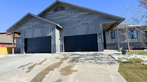 Ein zweistöckiges Gebäude mit Garage und überdachter Auffahrt.