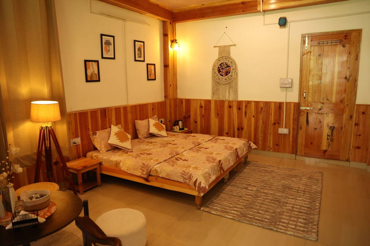 Un dormitorio acogedor con una cama de madera, una mesita de noche, una lámpara y un tapiz colgado en la pared.