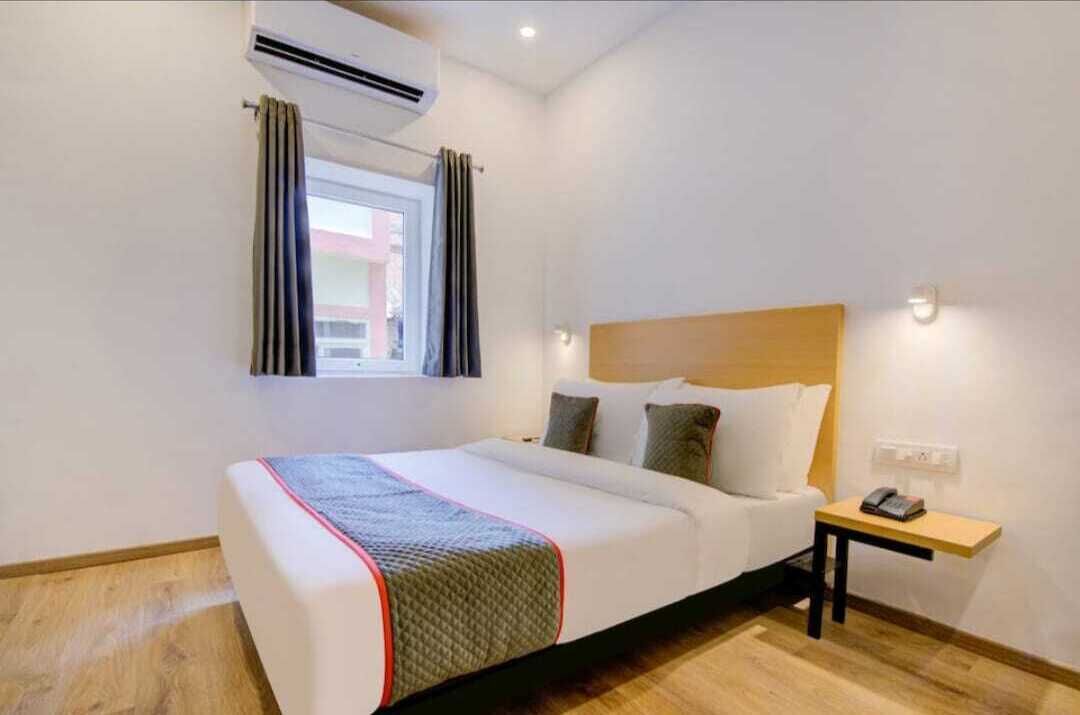 Une chambre d’hôtel équipée d’un lit, d’une table de chevet avec un téléphone et d’un appareil de climatisation.