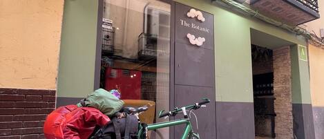 Una bicicleta verde estacionada frente a un edificio con un cartel que dice "The Botanic".