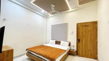 A modern bedroom with a bed, a wooden door, a ceiling fan, and a striped wall decoration.