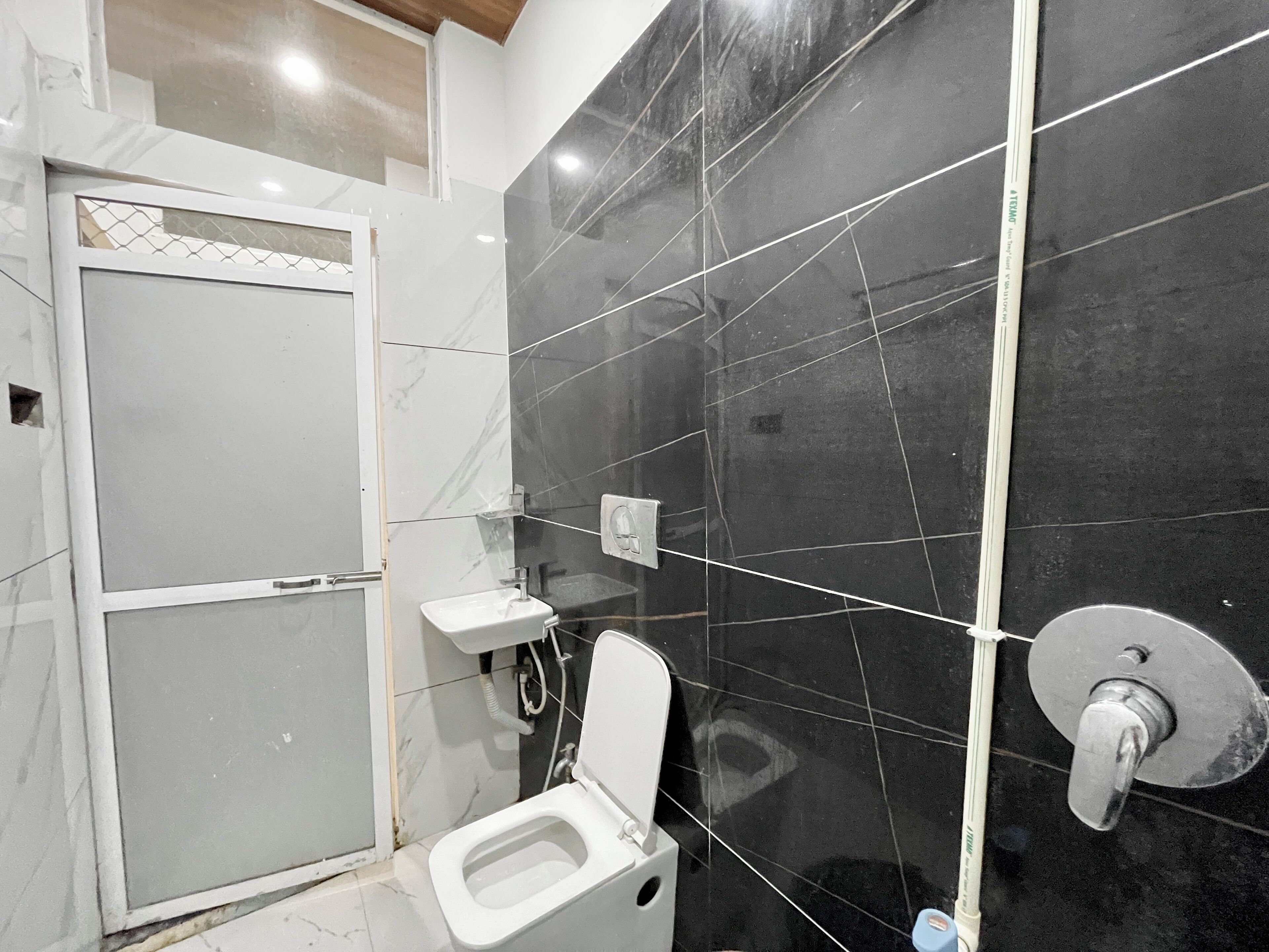 A bathroom with a toilet, sink, and a shower area.