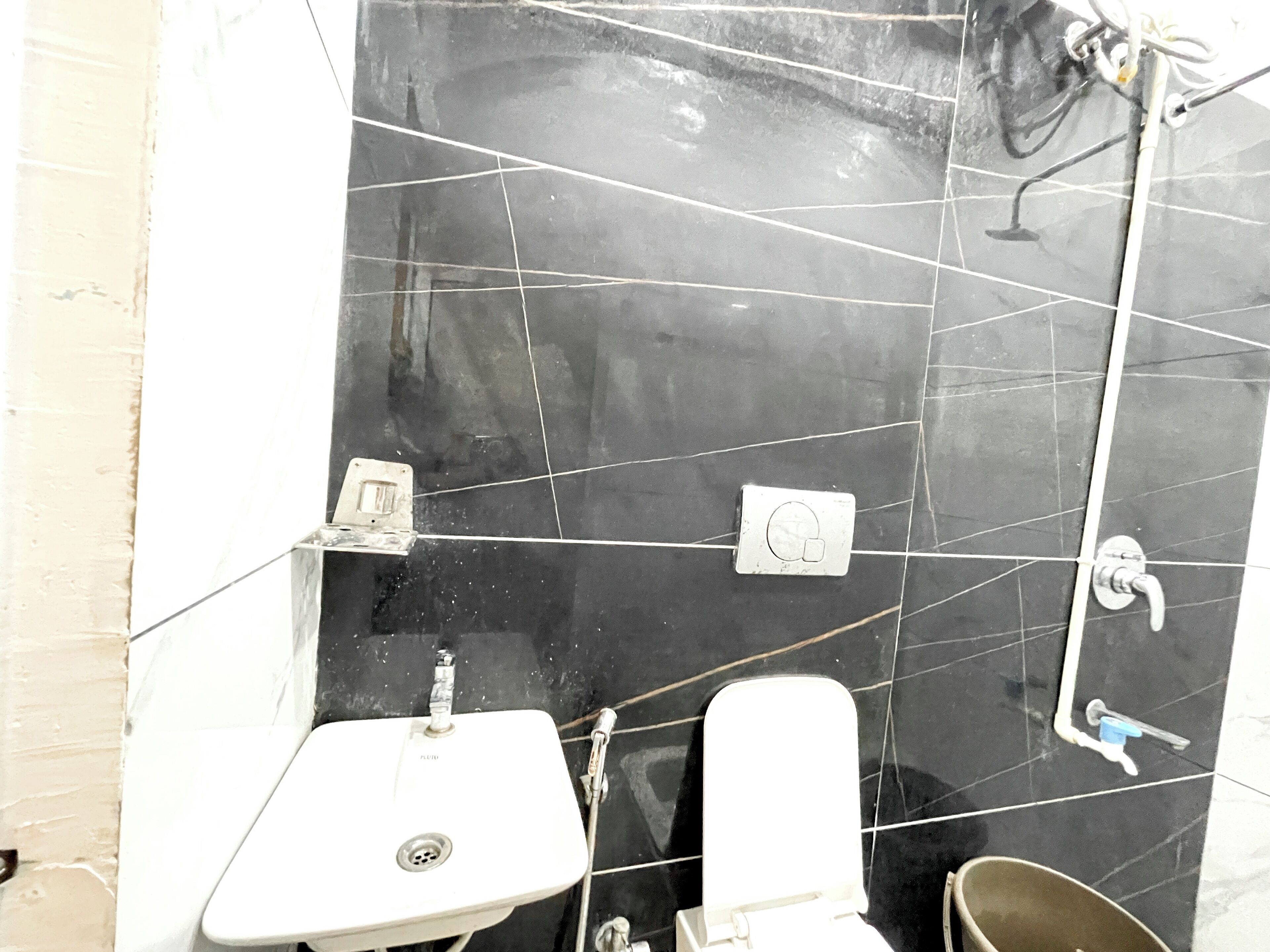 Casa de banho com lavatório branco, sanita e zona de duche.