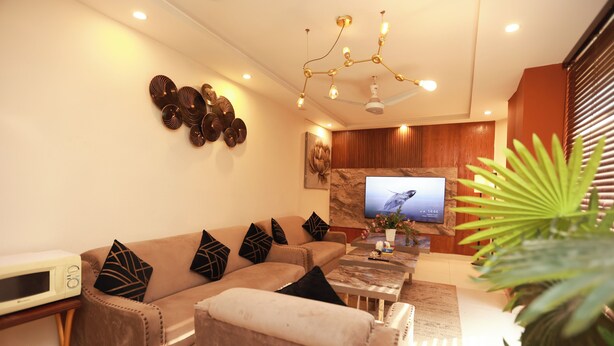 A modern living room with a sofa, coffee table, and a flat-screen TV. - Hotel Dream Heights Hotel and Apartment (Rawalpindi)