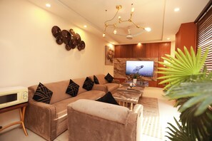 A modern living room with a sofa, coffee table, and a flat-screen TV. - Hotel Dream Heights Hotel and Apartment (Rawalpindi)