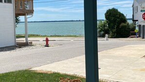 Una propiedad frente al agua con un porche cubierto, una señal de alto y vistas al lago.