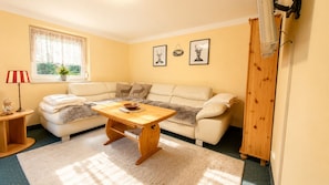 A cozy living room with a sofa, a wooden coffee table, a lamp, and framed pictures on the wall. - "Large vacation home for groups & families at the Rhododendron Park Kromlau" (Kromlau)