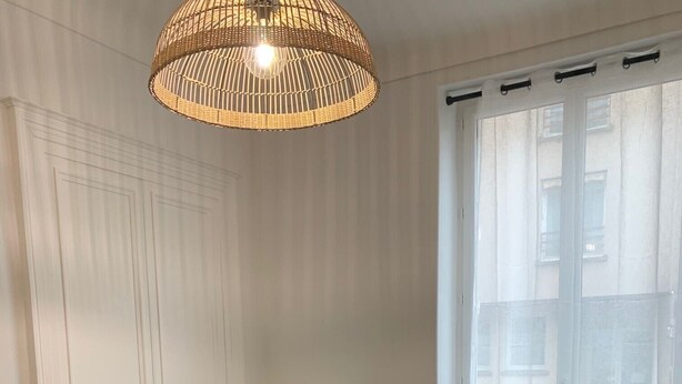 Ein modernes Wohnzimmer mit grauem Sofa, einem Esstisch und einem blauen Sessel.
