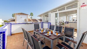 An outdoor dining area with a table set for breakfast, chairs, and a view of the cityscape. - Infinity Haven by Fidalsa (Villamartín)