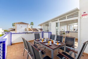 An outdoor dining area with a table set for breakfast, chairs, and a view of the cityscape. - Infinity Haven by Fidalsa (Villamartín)