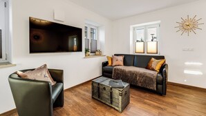 Una sala de estar con un sofá, un sillón y una maleta antigua.