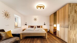 Un dormitorio moderno con una cama de madera, un armario, una mesita de noche y un reloj de pared decorativo.