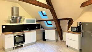 A compact kitchen with modern appliances, skylights, and exposed wooden beams. - Superb furnished and equipped T3 decorated for the festive season (Montluçon)