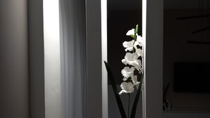 A modern interior with a potted plant and a vase with white flowers. - Elite Apartment Larisa (Larissa)