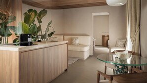 A modern kitchen with a central island, a dining area with a glass table, and a living space with a sofa and a coffee table. - Mode Eco Mood Hotel (Rimini)