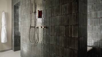 Une salle de bain moderne dotée d’une grande douche, d’un porte-serviettes et d’un lavabo.