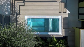A modern outdoor pool with a geometric design, surrounded by wooden decking and lush greenery. - Mode Eco Mood Hotel (Rimini)