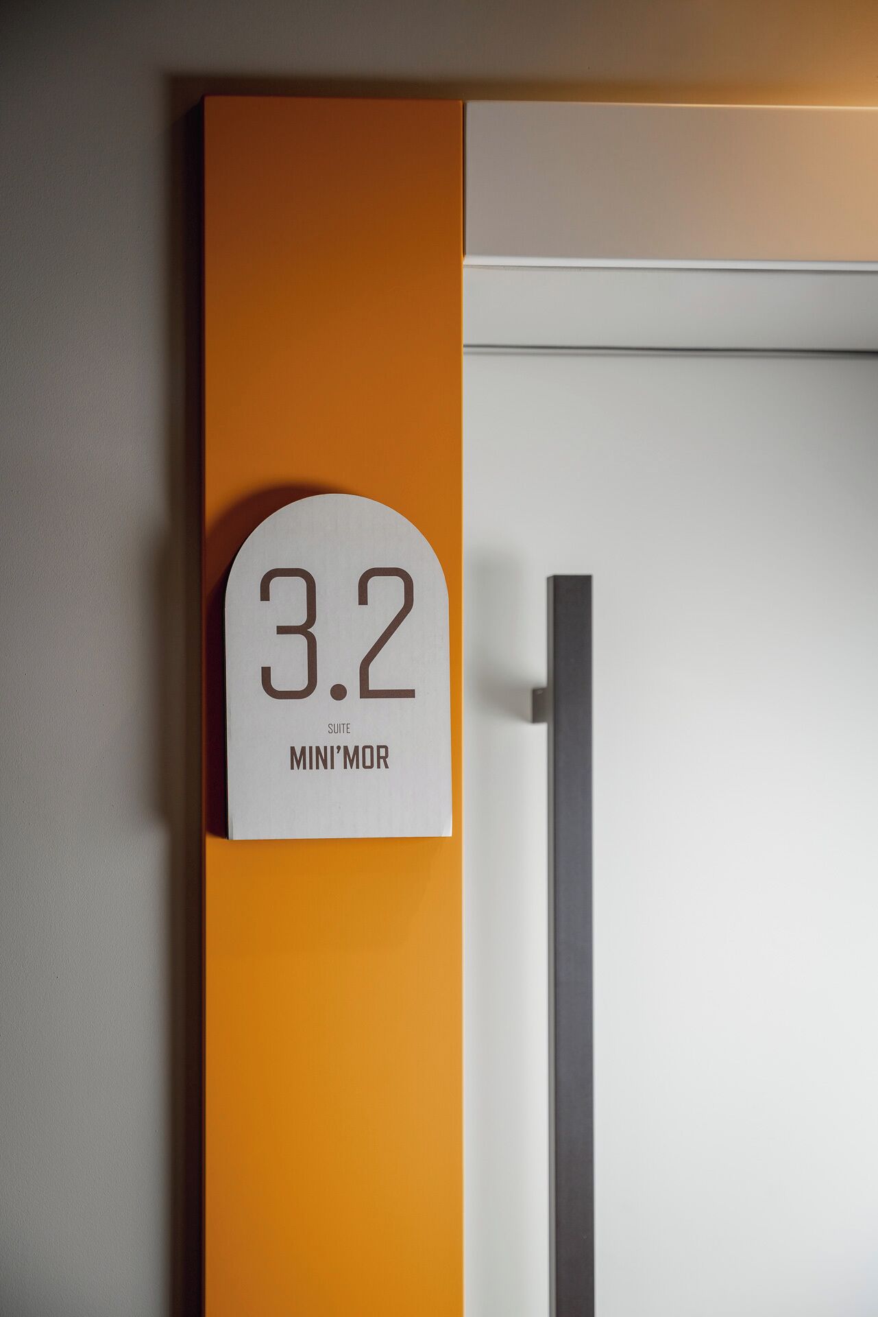 A room number sign with '3.2' and 'SUITE MINI'MOR' indicating the room's designation.