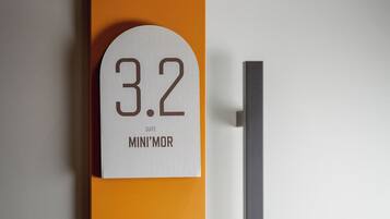 A room number sign with '3.2' and 'SUITE MINI'MOR' indicating the room's designation.