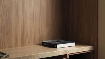 A wooden desk with a book titled "Look" and a hair dryer in a cabinet.