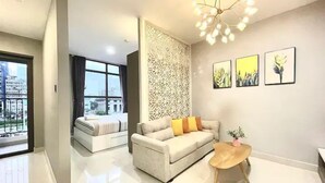 A modern living room with a sofa, a coffee table, and a decorative wall panel. - Saigon Royal View Residence & River (Ho Chi Minh City)