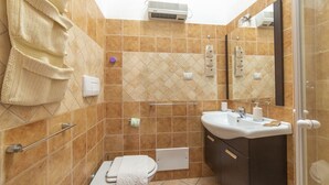 A bathroom with a toilet, sink, and shower area. - Trilocale Apartments Seaside (Villaputzu)