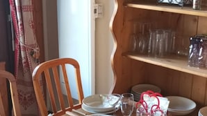 Een eettafel gedekt met borden, glazen en een mand met brood.
