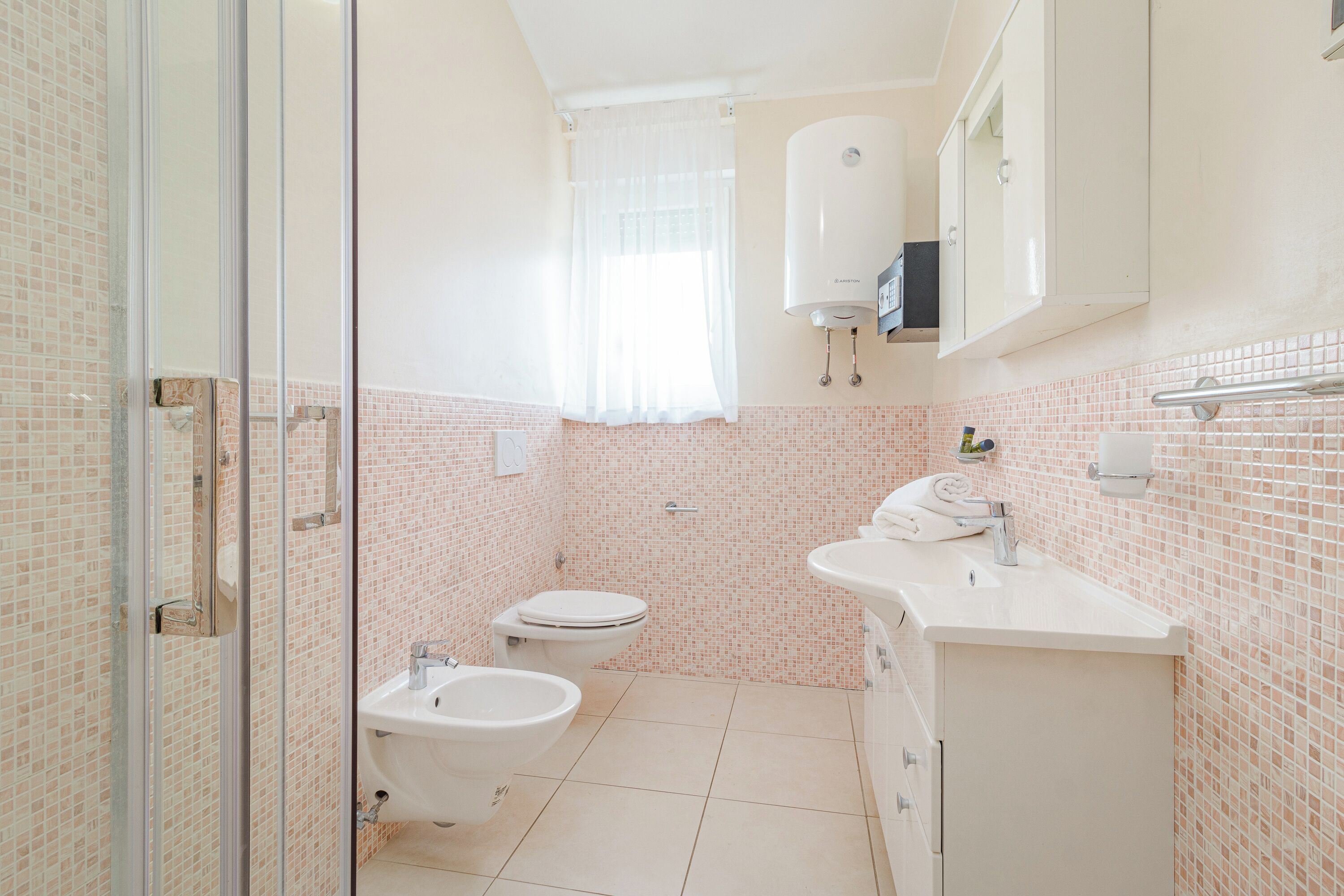 A bathroom with a toilet, bidet, and sink.