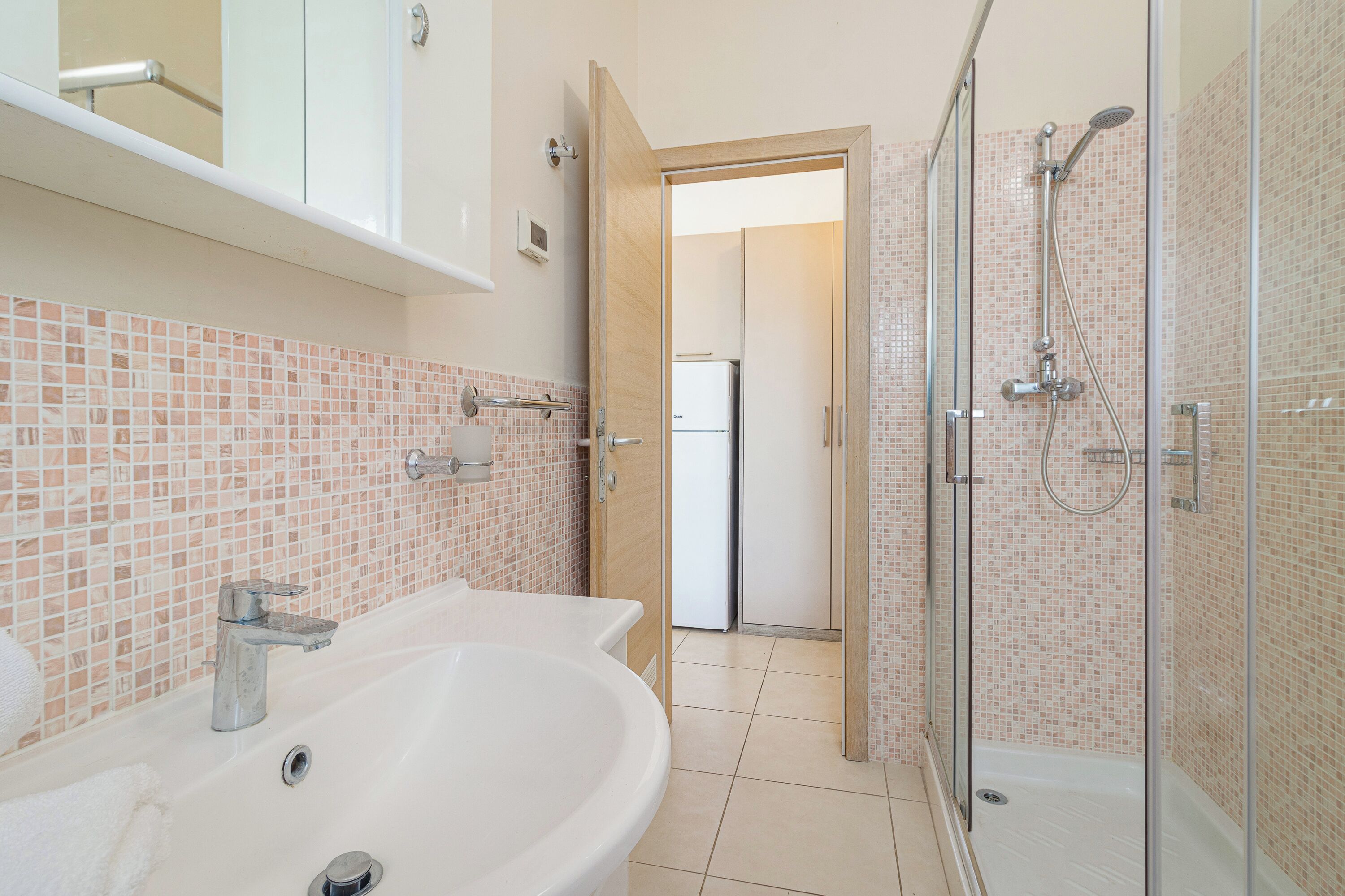 A bathroom with a sink, shower, and toilet.