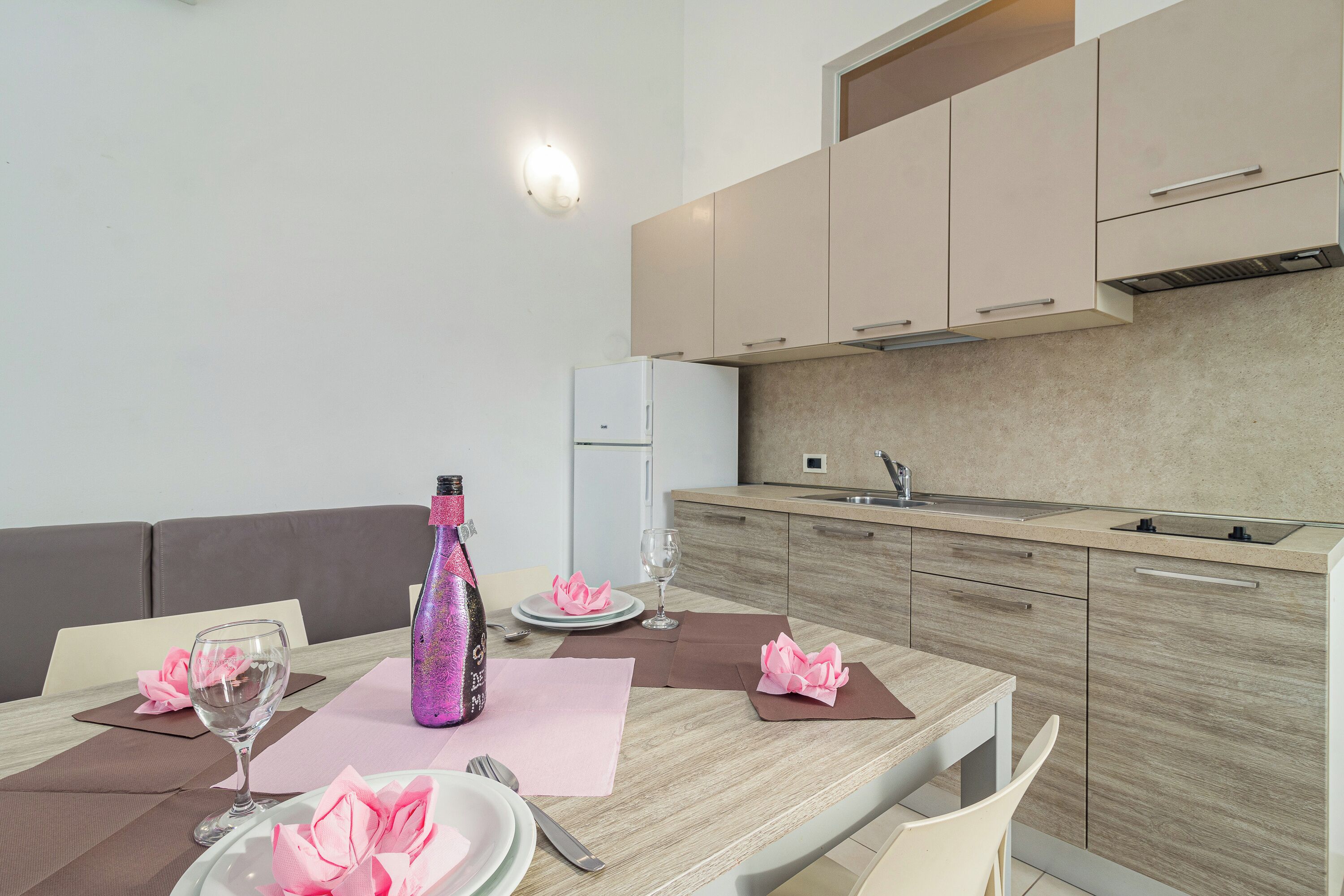 A modern kitchen with wooden cabinets, a built-in oven, and a sink.
