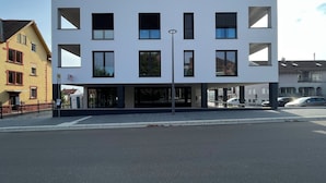 Ein modernes Gebäude mit mehreren Etagen, großen Fenstern und einem Flachdach.