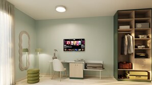 Ein modernes Zimmer mit Flachbildfernseher an der Wand, der eine Auswahl an Filmen zeigt.