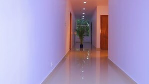 A long, narrow hallway with a shiny floor and recessed lighting.