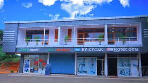 A building with multiple storefronts including 'Green Apple', 'By Cycle', and 'Home Gym'.