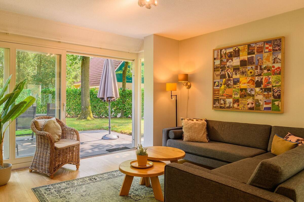 A cozy living room with a sofa, a wicker chair, a small table, and a potted plant.