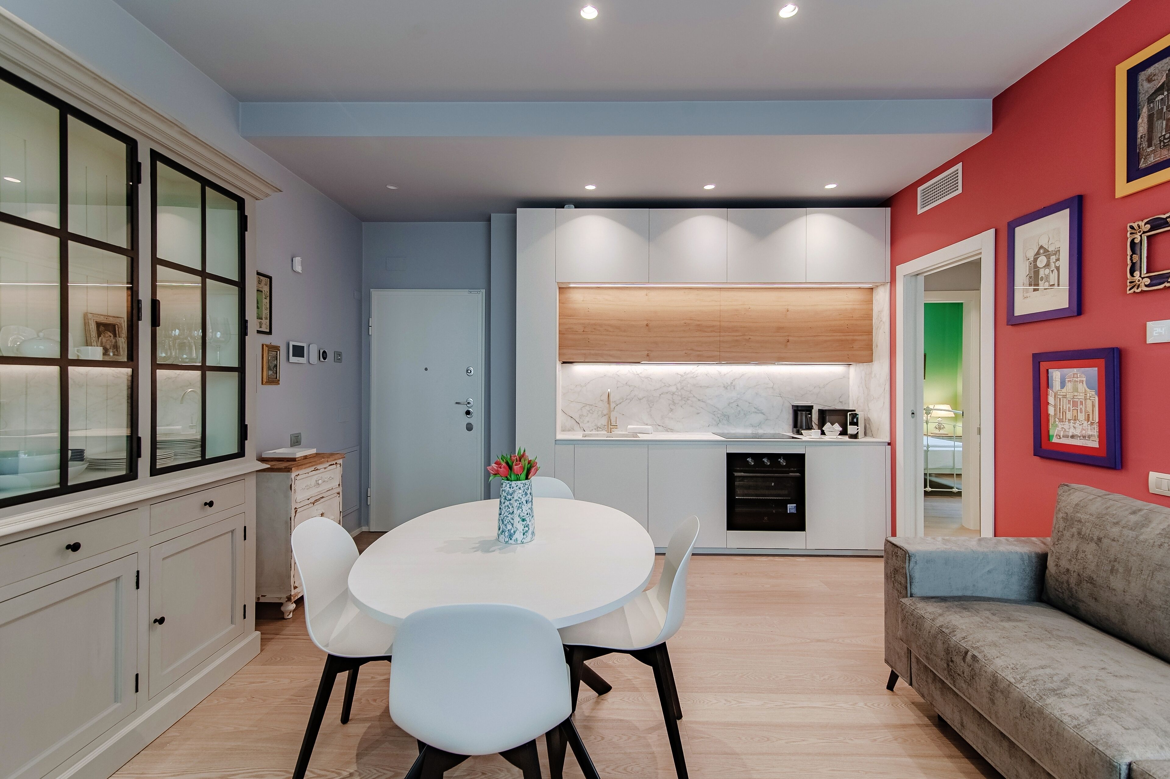 A modern kitchen with a white countertop, a built-in oven, and a wooden backsplash.