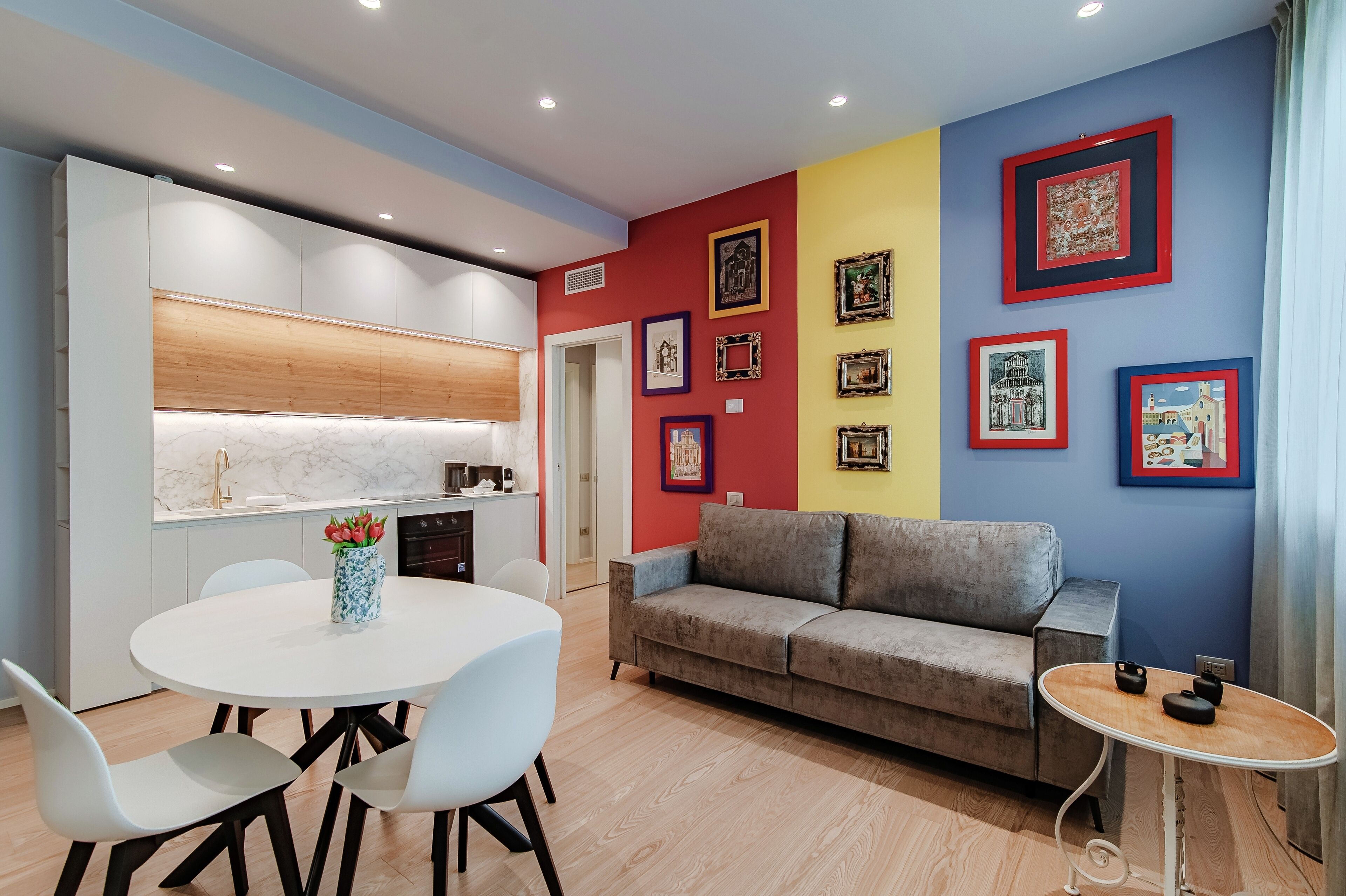 A modern living space with a kitchen, dining area, and a sofa.