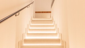 A staircase with illuminated steps and a wooden panel at the top. - Retiro: Comfortable flat in the area of Delicias (Madrid)