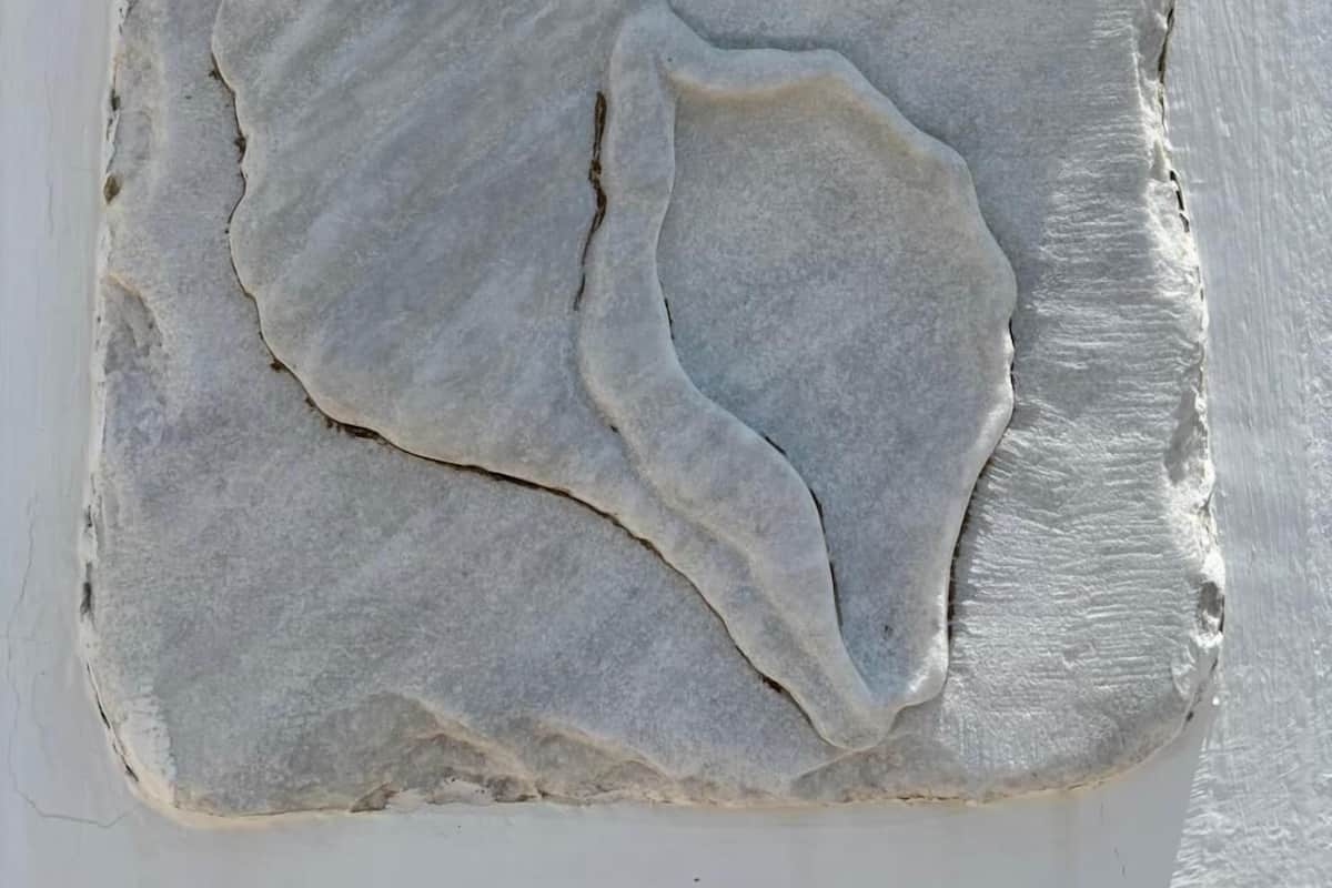 Une pierre portant l'inscription « NEPTUNEA » et ornée d'un motif en forme de coquillage.