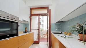 Eine moderne Küche mit Holzausstattung, einem eingebauten Ofen und einer Marmorarbeitsplatte.